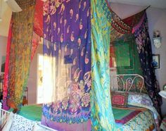 the canopy bed is decorated with colorful fabrics