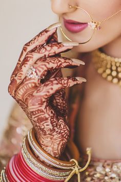 a woman with henna on her face and hands