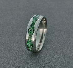 -Mineral(s): Peridot, Howlite -Opal(s): Green Opal -Ring Material: Stainless Steel 316L -Ring Width: 6mm, 8mm -Shipping: EU:6-10 Workdays, Outside The EU: 7- 14 Workdays -Ring Inside: Comfort Fit Elevate your jewelry collection with this captivating stainless steel ring featuring a remarkable inlay crafted with crushed peridot, howlite minerals, and green opal. With a blend of vibrant green hues, this unique piece carries a deep symbolism that resonates with nature's wonders. Peridot, known for its refreshing and invigorating energy, represents growth, renewal, and abundance. It is believed to promote harmony, clarity, and positivity. The lively green color of peridot infuses a sense of vitality and optimism into your daily life. Howlite, with its distinctive marbled appearance, embodies c Elegant Green Rings With Inlay, Green Opal Wedding Jewelry, Elegant Green Inlay Rings, Green Inlay Rings For Anniversary, Green Anniversary Rings With Inlay, Anniversary Green Inlay Rings, Green Opal Sterling Silver Wedding Ring, Green Opal Ring For Anniversary, Green Opal Promise Ring