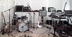 a room filled with musical instruments and sound equipment on top of carpeted flooring