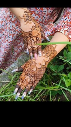 a woman holding her hands with henna on it