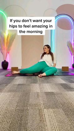 a woman is sitting on the floor with her legs crossed and looking up at something