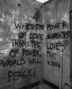 an old wall with graffiti written on it and another word that says, when the power of love is greater than the power of world will peace