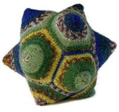 a green and blue pillow sitting on top of a white floor