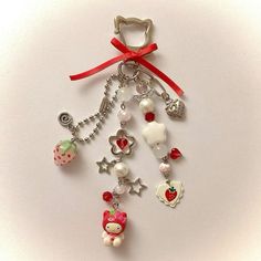 a key chain with various charms hanging from it's sides on a white surface