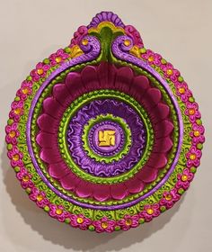 an intricately designed paper plate is displayed on a white surface with pink, green and yellow accents