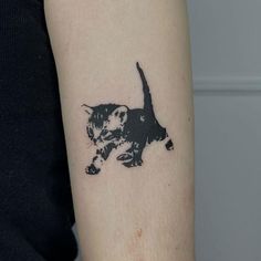 a black and white cat tattoo on the arm