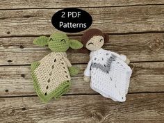 two crocheted stuffed animals laying next to each other on a wooden surface,