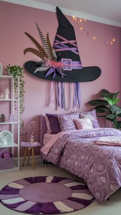 a bedroom decorated in pink and purple with a large witch hat hanging above the bed