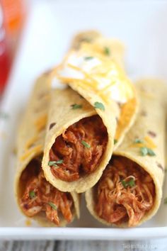 shredded meat burritos on a white plate