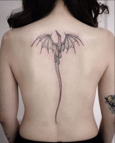 a woman with a dragon tattoo on her back