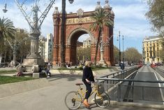 a person riding a bike in front of an arch