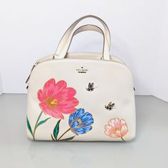 Check Out This Double Handle Satchel With Flowers And Bee Charms From Kate Spade In Cream. Brand Name: Kate Spade New York Market: Women Unisex Color: Cream Pink Blue Gold Green Retail Price: $425 Style: Double Handle, Zip Top, Inner Dividers, Inner Pockets, Detachable Crossbody Strap, Bumble Bee Charms, Floral, Picnic Perfect Bee Lottie Handbag, Spring, Pxru8822 Material: Leather Metal Approximate Measurements: 12 In Wide, 9 In Tall, 5 In Deep, 5 In Drop Condition: Light Wear On Corners/Bottom Check Out My Other Listings And Bundle Them For A Special Discount. Don't Miss Out On This Cream Picnic Perfect Bee Lottle Satchel By Kate Spade. Floral Picnic, Bee Charms, Spring Colors, Women Accessories Bags, Kate Spade Bag, Spring Floral, Zip Top, Crossbody Strap, Bumble Bee