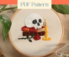 a cross stitch pattern with a skeleton holding a lit candle in it's hand