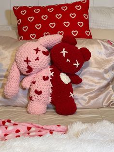 two crocheted teddy bears sitting on top of a bed next to each other