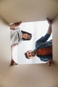 two men standing in an open cardboard box