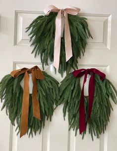 two wreaths are hanging on the front door