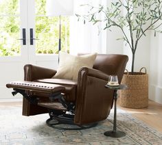 a brown recliner chair sitting on top of a wooden floor next to a window