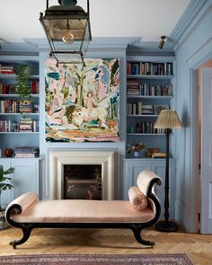 a living room filled with furniture and a fire place in front of a book shelf