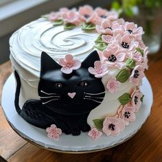 a cake decorated with flowers and a black cat