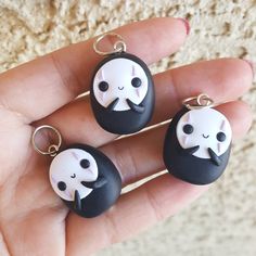 two black and white keychains with faces on them