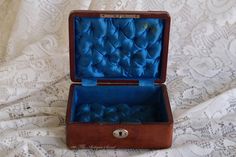 an open wooden box sitting on top of a bed