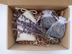 two soaps in a box with lavender on the top and white bags next to them