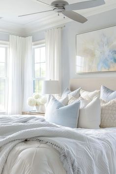 a bed with white sheets and pillows in a bedroom