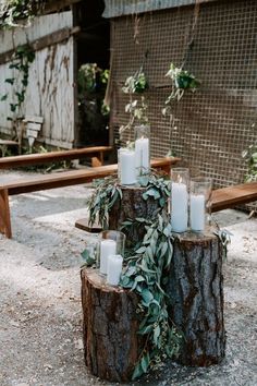 candles are placed on top of a tree stump in the middle of an outdoor area