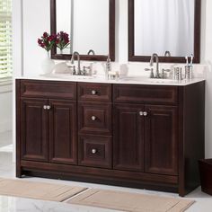 a bathroom vanity with two sinks and mirrors