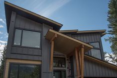 a large gray house with wood trim and windows