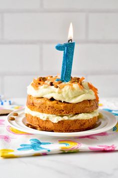 a birthday cake sitting on top of a plate with a candle in the shape of an 1