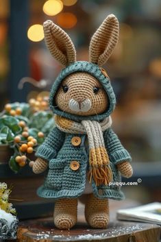 a crocheted rabbit wearing a coat and scarf