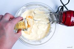 someone mixing cream in a glass bowl with a whisk attachment on the side