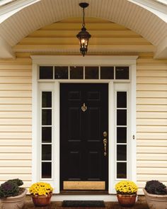 the front door to a house with two flower pots