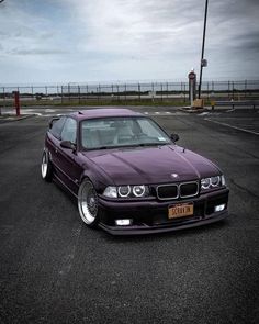 a purple car parked in a parking lot next to an empty parking lot with no cars