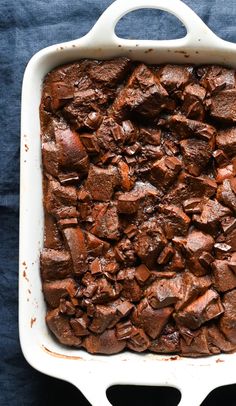 a casserole dish filled with brownies on top of a blue cloth