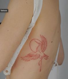 a tattoo on the back of a woman's left arm with a bird flying over it