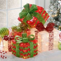 presents are wrapped in red and green paper with bows on them, surrounded by christmas decorations