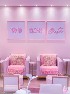 two pink chairs in a room with pictures on the wall behind them that say we are cute