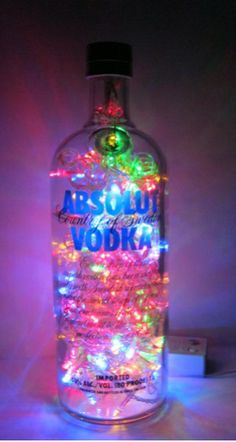 a bottle that has some lights on it and is lit up with the words absolut vodka