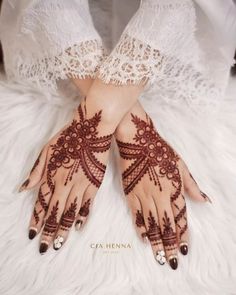 a woman's hands with henna tattoos on them