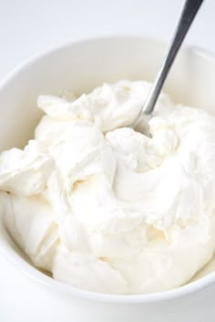 a white bowl filled with whipped cream and a spoon