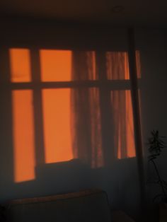 the sun is shining through the window in the room with the curtains pulled back and casting shadows on the wall