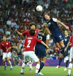 a group of young men playing soccer against each other in front of a large crowd