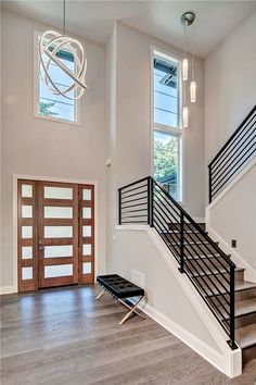 a staircase leading up to the second floor in a modern home with wood floors and white walls