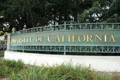 the university of california sign in front of some trees