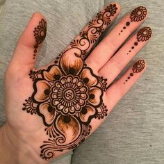 a woman's hand with henna tattoos on it