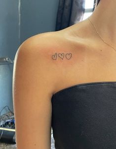 a woman with a heart tattoo on her left shoulder and the word love written in cursive letters