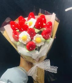 a person holding a bouquet of flowers made out of crochet